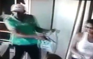 Bandido apontando arma para funcionárias no momento do assalto